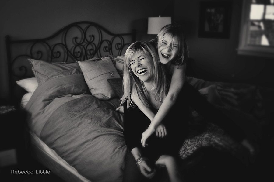 Black and white authentic family photos Sierra Madre.Mom and daughter laughing on the bed shot by Rebecca Little