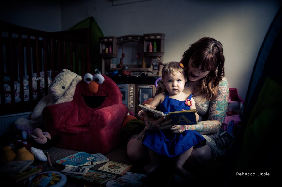 Artistic family photo of Mom reading to her daughter as the light streams through the window. Shot by Rebecca Little Photography Pasadena, CA.