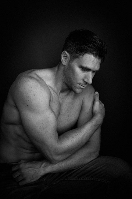 Chris is an Australian actor who need headshots. I created about 80 headshots showing him in different roles. This image is in black and white and shows off his strongly muscled arms. He is sitting down and his arms are wrapped around himself. The image is cropped close so we focus on his physique. I love shooting actors like Chris Atkins and making creative headshots. We created so may different looks, from boy-next-door, to tough guy bouncer, to upscale sophisticate, to fitness model, to some wrestling and military poses. Chris was in the WWE training program in Florida and is now living in Los Angeles and pursing many opportunities, including acting. He knows how important headshots are for actors who are trying to be seen by casting directors. We shot in my photo studio on Green Street in Pasadena and on location outside on the street with backgrounds like red brick walls and gritty urban areas and tree-lined streets.