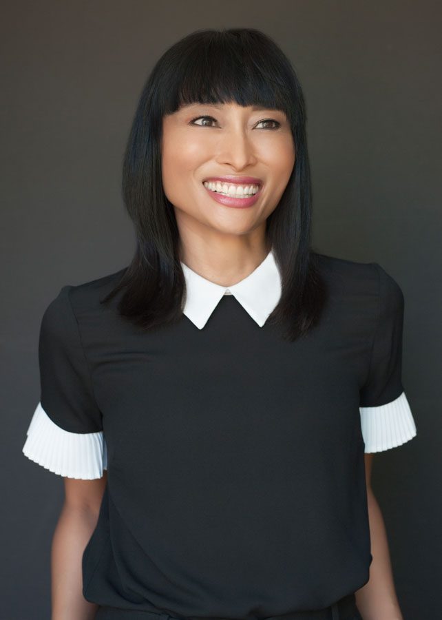 I create updated headshots for you job search, like this one. The woman is wearing a black shirt with a white pointed collar and white pleated short sleeves. She's smiling and happy and is looking slightly to the right of camera. Her teeth are white and her eyes are dark. Image created by Rebecca Little Photography in Pasadena, CA.